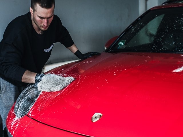 Pracownik  myjący Porsche na ręcznej myjni samochodowej na Krucza 18 w Osielsku obok Bydgoszczy.